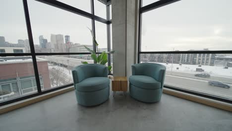 Chairs-Against-Large-City-Facing-Windows-in-Downtown-Minneapolis-Condo-with-Skyline-View