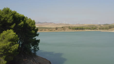 Small-island-in-lake-Caminito-del-Rey,Spain,wind-turbines-in-distance