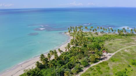 Aerial-view-overlooking-palm-trees-and-shallow-turquoise-waters-at-the-Playa-Costa-Esmeralda,-in-Miches,-DR---orbit,-drone-shot