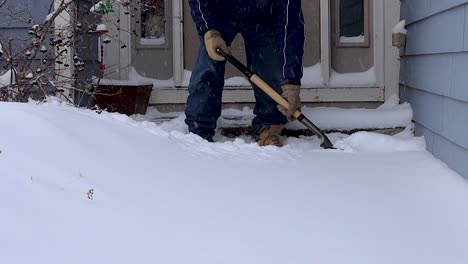 Scooping-snow-to-clear-the-front-stoop-after-a-winter-storm