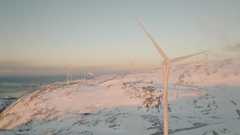 Aerial-view-of-wind-turbine-farm-at-sunrise-in-mountain-landscape
