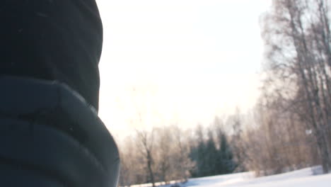 Person-walking-through-deep-snow-wearing-winter-shoes,-close-up-back-shot