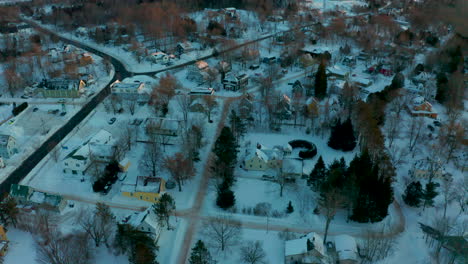 Picturesque-winter-aerial-flying-over-a-snow-covered-small-town-neighborhood