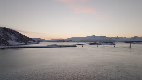 Cinematic-aerial-shot-of-a-sunrise-over-Sommaroya-bridge-in-Norway
