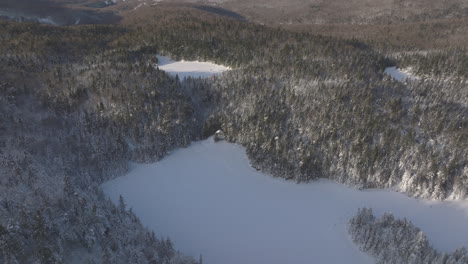 Lago-Helado-Rodeado-De-Densos-árboles-De-Coníferas-En-El-Bosque-Invernal-Cerca-De-Sutton,-Quebec,-Canadá