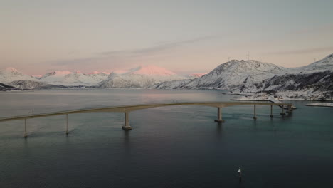 Vista-Aérea-Del-Puente-A-La-Isla-De-Sommaroya,-Día-De-Invierno-En-Noruega---Disparo-De-Drones