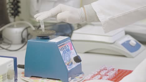 Scientist-use-blue-vortex-mixer-for-test-tubes-in-laboratory