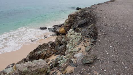 Sea-wall-and-ocean-road-damage-and-corrosion,-crumbling-away-into-ocean,-impacts-of-climate-change,-rising-tides-and-lack-of-maintenance