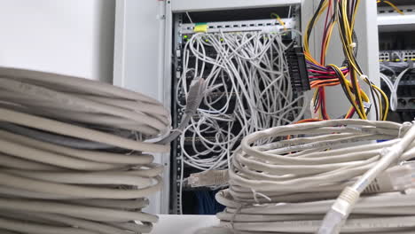Network-of-many-cables-in-local-server-room,-motion-forward-shot