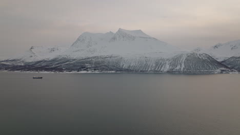 Großes-Boot-Segelt-An-Der-Küste-Von-Norwegen-Mit-Schneebedeckten-Bergen-Im-Hintergrund