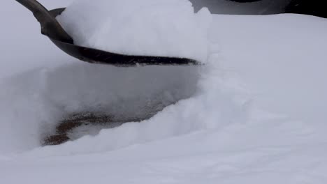 A-scoop-shovel-clears-snow-from-a-neighborhood-sidewalk