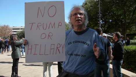 Older-White-Male-With-Anti-Establishment-Sign-Saying-No-To-Both-Hillary-Clinton-And-Donald-Trump,-Iowa-Caucus