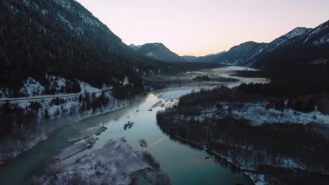 Scenic-Bavarian-Austrian-alps-mountain-valley-river-with-fresh-water-at-Sylvensteinspeicher-by-sunshine-sunset,-winter-snow-riverbed,-trees-and-forest-and-mountains
