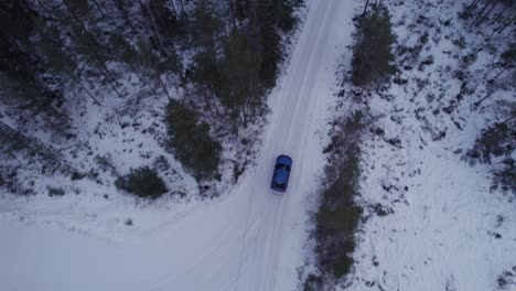 Winter-road-Top-view-over-blue-Car-in-the-Forest