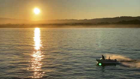 Ein-Motorboot-Rutscht-Bei-Sonnenaufgang-über-Das-Wasser-Im-Hafen-Von-Monterey