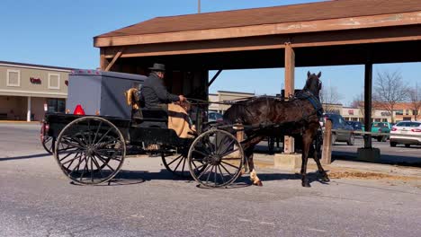 Un-Hombre-Amish-Conduce-Su-Caballo-Y-Su-Buggy-Al-Estacionamiento-De-Un-Centro-Comercial-En-Pennsylvania-Y-Lo-Estaciona-En-Un-área-Especial