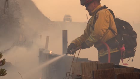 Feuerwehrleute-Setzen-Einen-Schlauch-Und-Wasser-Gegen-Die-Flammen-Des-Alisal-feuers-Ein,-Das-Entlang-Der-Küste-Von-Gaviota-Im-Bezirk-Santa-Barbara-Brennt