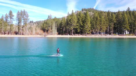 Un-Hombre-Monta-Una-Tabla-De-Surf-Electrónica-Efoil-Hoverboard-De-Hidroala-A-Través-Del-Lago-Tahoe,-California-En-Una-Demostración-De-Deporte-De-Lámina-De-Hidroala-Extrema