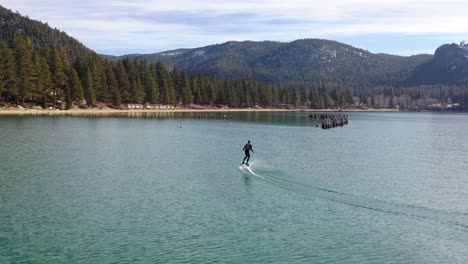 Un-Hombre-Monta-Una-Tabla-De-Surf-Electrónica-Efoil-Hoverboard-De-Hidroala-A-Través-Del-Lago-Tahoe,-California-En-Una-Demostración-De-Deporte-De-Lámina-De-Hidroala-Extrema