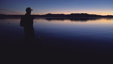Ein-Mann-Fischt-Und-Geht-Im-Morgengrauen-Oder-Sonnenuntergang-Am-Lake-Tahoe,-Kalifornien,-Nevada-Fischen