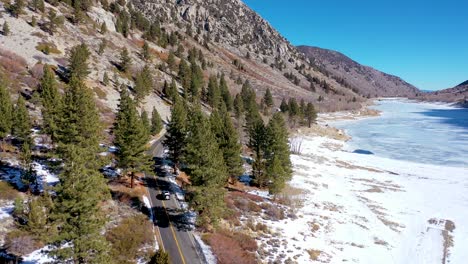 Antena-De-Un-Vehículo-Todoterreno-4x4-Que-Conduce-Por-Una-Carretera-De-Montaña-Remota-En-Invierno-Cerca-De-Yosemite-O-Mammoth-California