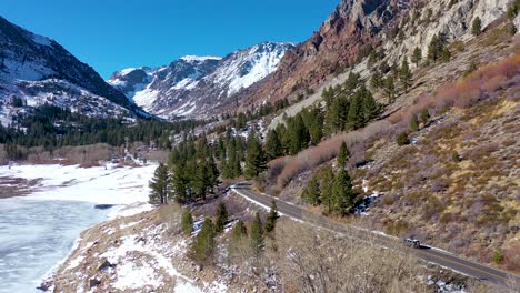 Aerial-Of-A-4X4-Jeep-Vehicle-Driving-On-A-Remote-Moutain-Road-In-Winter-Near-Yosemite-Or-Mammoth-California