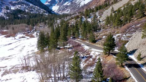 Antena-De-Un-Vehículo-Todoterreno-4x4-Que-Conduce-Por-Una-Carretera-De-Montaña-Remota-En-Invierno-Cerca-De-Yosemite-O-Mammoth-California