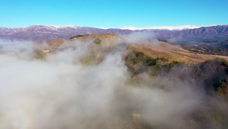 Aerial-Over-Clouds-And-Fog-Reveals-The-Ojai-Valley-And-Snow-Covered-Topatopa-Mountains-In-Winter