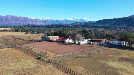 Aerial-Over-Farm-Fields-Reveals-The-Ojai-Valley-And-Snow-Covered-Topatopa-Mountains-In-Winter