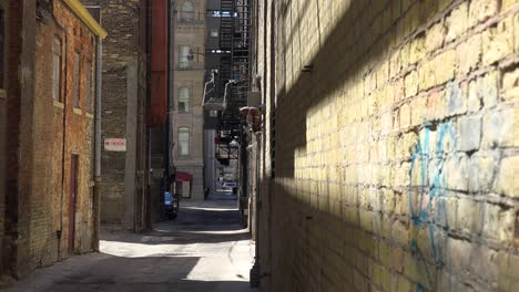 Establishing-Shot-Of-An-Empty-Alley-In-An-Inner-City-And-A-Homeless-Man-Walks-Through