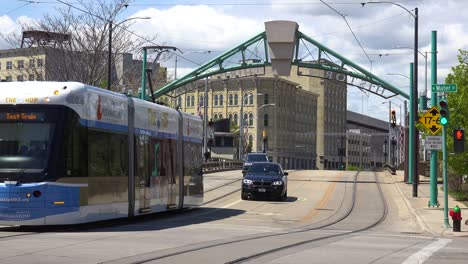 Electric-Trams-Transit-Trains-Move-Down-A-Street-In-Downtown-Milwaukee,-Wisconsin
