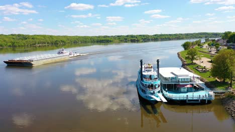 Very-Good-Drone-Aerial-Along-The-Mississippi-River-At-Le-Claire,-Iowa-Of-Old-Riverboat-And-Barge-Heading-Upstream