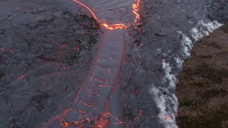 Top-Down-High-Angle-Drone-Aerial-Of-Molten-Lava-Fields-And-Snow-Falling-At-The-Fagradalsfjall-Volcano-Eruption-In-Iceland