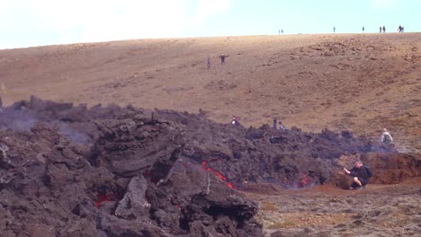 Los-Turistas-Caminan-Hasta-El-Borde-Del-Flujo-De-Lava-Volcánica-Durante-La-Erupción-Explosiva-Volcánica-Del-Volcán-Fagradalsfjall-En-Islandia