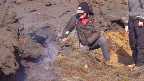 Los-Turistas-Caminan-Hasta-El-Borde-Del-Flujo-De-Lava-Volcánica-Y-Asan-Malvaviscos-Durante-La-Erupción-Explosiva-Volcánica-Del-Volcán-Fagradalsfjall-En-Islandia