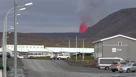 The-Fagradalsfjall-Volcano-Is-Seen-Erupting-In-The-Distance-Behind-The-Town-Of-Grindavik,-Iceland