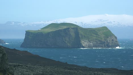 Una-Cabaña-De-Verano-Remota-Y-Solitaria-En-Una-Pequeña-Isla-En-Las-Islas-Westman-De-Islandia-Con-El-Glaciar-Mýrdalsjökull-En-El-Fondo
