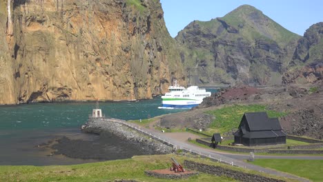 The-Westman-Islands-All-Electric-Powered-Ferry-Boat-Arrives-At-Vestmannaeyjar-Passing-A-Norwegian-Stave-Church