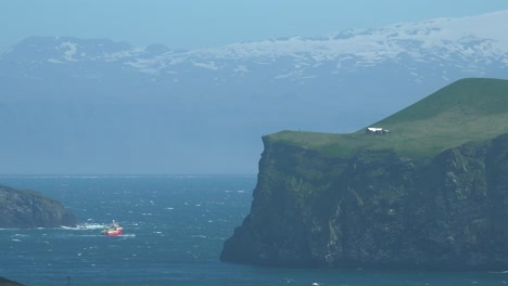 An-Icelandic-Fishing-Boat-Battles-Difficult-Waves-Along-A-Remote-Coast-Of-The-Westman-Islands,-Iceland