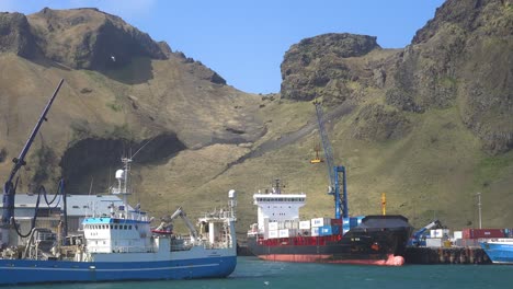 Cargo-Ships-Load-Containers-Full-Of-Fish-At-The-Fishing-Port-Of-Vestmannaeyjar-In-The-Westman-Islands,-Iceland