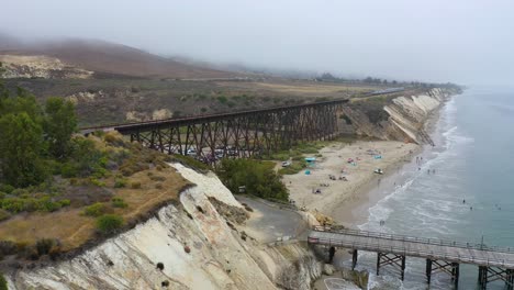Gute-Antenne-Des-Amtrak-Personenzugs,-Der-Die-Brücke-Im-Nebel-Entlang-Der-Kalifornischen-Küste-Am-Gaviota-State-Beach-überquert