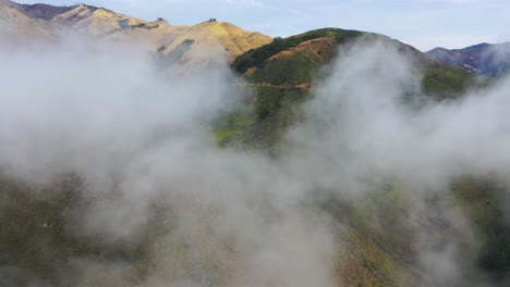 Eine-Aufsteigende-Luftaufnahme-Durch-Den-Nebel-Zeigt-Die-Abgelegenen-Berge-Entlang-Des-Kalifornischen-Highway-One-Pacific-Coast-Highway-In-Der-Nähe-Von-Big-Sur