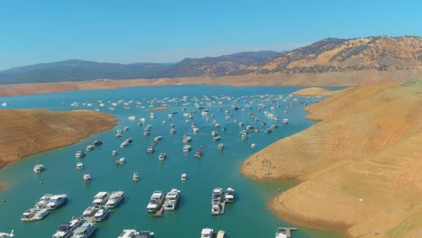 Erstaunliche-Luftaufnahme-über-Dem-Von-Der-Dürre-Betroffenen-Kalifornischen-Oroville-See-Mit-Niedrigem-Wasserstand,-Zurückweichender-Küstenlinie-Und-Gestrandeten-Hausbooten