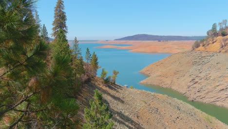 Amazing-Aerial-Over-Drought-Stricken-California-Lake-Oroville-With-Low-Water-Levels,-Receding-Shoreline-And-Burned-Trees-And-Forests