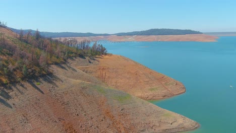 Amazing-Aerial-Over-Drought-Stricken-California-Lake-Oroville-With-Low-Water-Levels,-Receding-Shoreline-And-Burned-Trees-And-Forests