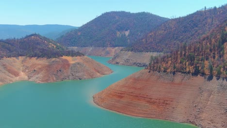 Disturbing-Aerial-Over-Drought-Stricken-California-Lake-Oroville-With-Low-Water-Levels,-Receding-Shoreline-And-Boats-In-The-Low-Water