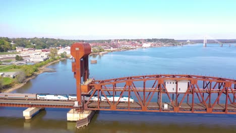 Aerial-Of-An-Amtrak-Passenger-Train-Crosses-The-Mississippi-River-On-A-Steel-Drawbridge-Near-Burlington,-Iowa