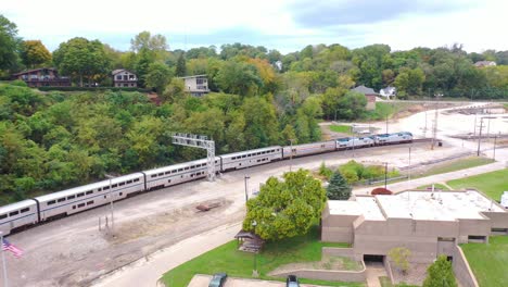 Antenne-Eines-Langstrecken-Amtrak-Personenzuges-Kommt-In-Einem-Rangierbahnhof-In-Der-Nähe-Von-Burlington,-Iowa-An