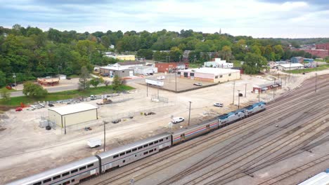 Antenne-Eines-Langstrecken-Amtrak-Personenzuges-Kommt-In-Einem-Rangierbahnhof-In-Der-Nähe-Von-Burlington,-Iowa-An
