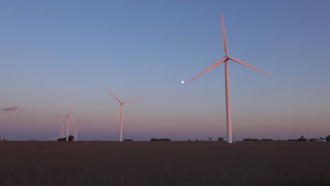 Der-Mond-Geht-Hinter-Windmühlen-Auf,-Die-Sich-Auf-Den-Flachen-Landwirtschaftsflächen-Von-Zentralindiana-Und-Illinois-Drehen-Und-Saubere-Energie-Erzeugen